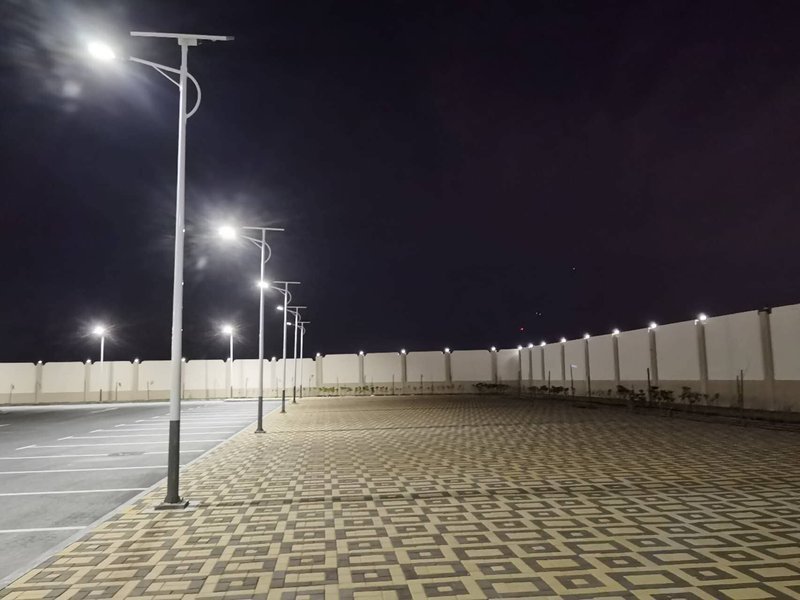 Walled car park lit at night by single-arm split units
